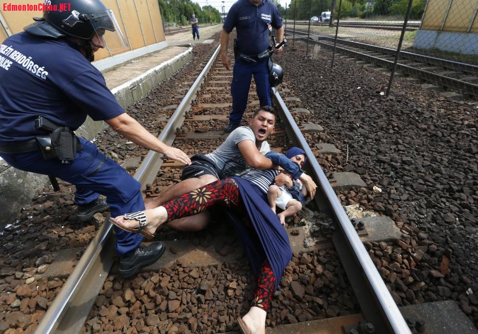 134284_story__refugee-pushes-family-on-train-tracks.jpg